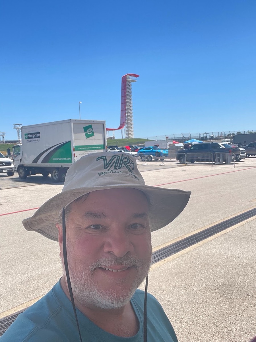 Me in the COTA paddock in a VIR hat, tower in the background