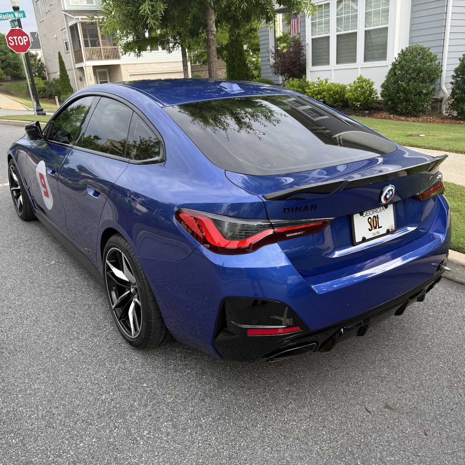 A blue BMW M440i with DINAN badging and a license plate that reads SQL, parked in a residential driveway.